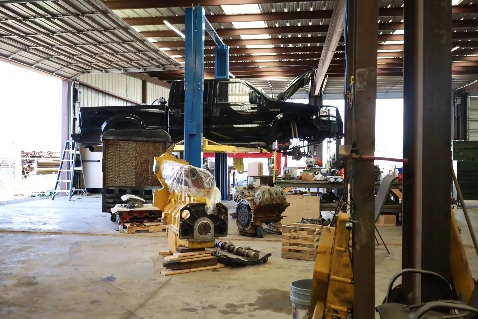 Pickup truck on a lift in MIdland TX auto repair shop undergoing diagnostics & diesel engine repair