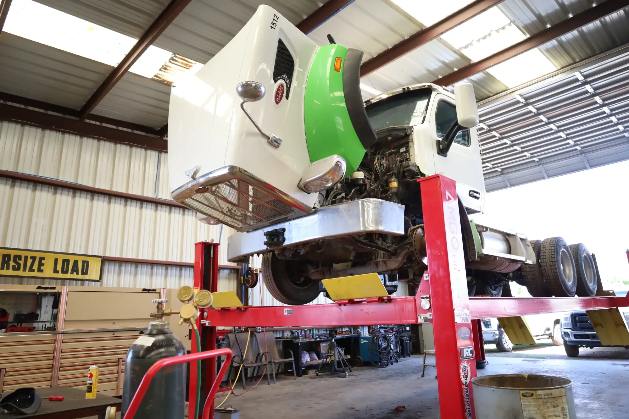 A truck is elevated on a lift stand for maintenance at a fleet repair service in Midland, Texas.