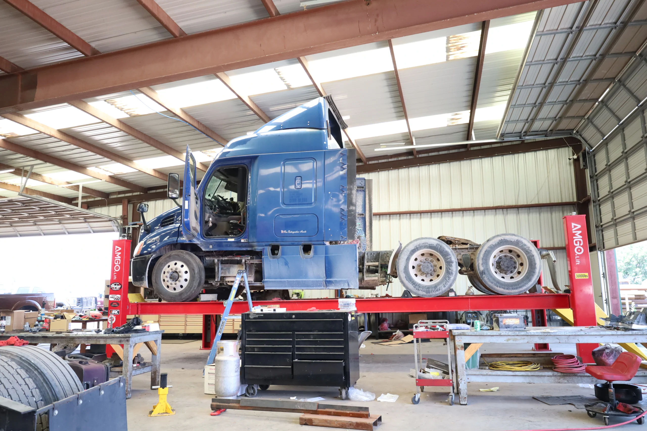 Semi truck repair in progress on heavy-duty lift at Chris's Diesel Service shop Midland TX