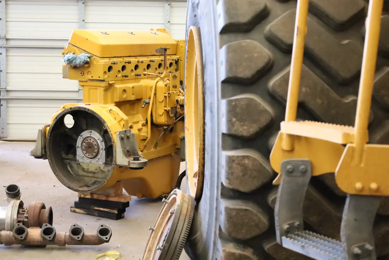 Heavy equipment diesel engine torn down with the head removed and turbo and flywheel
set aside for rebuild