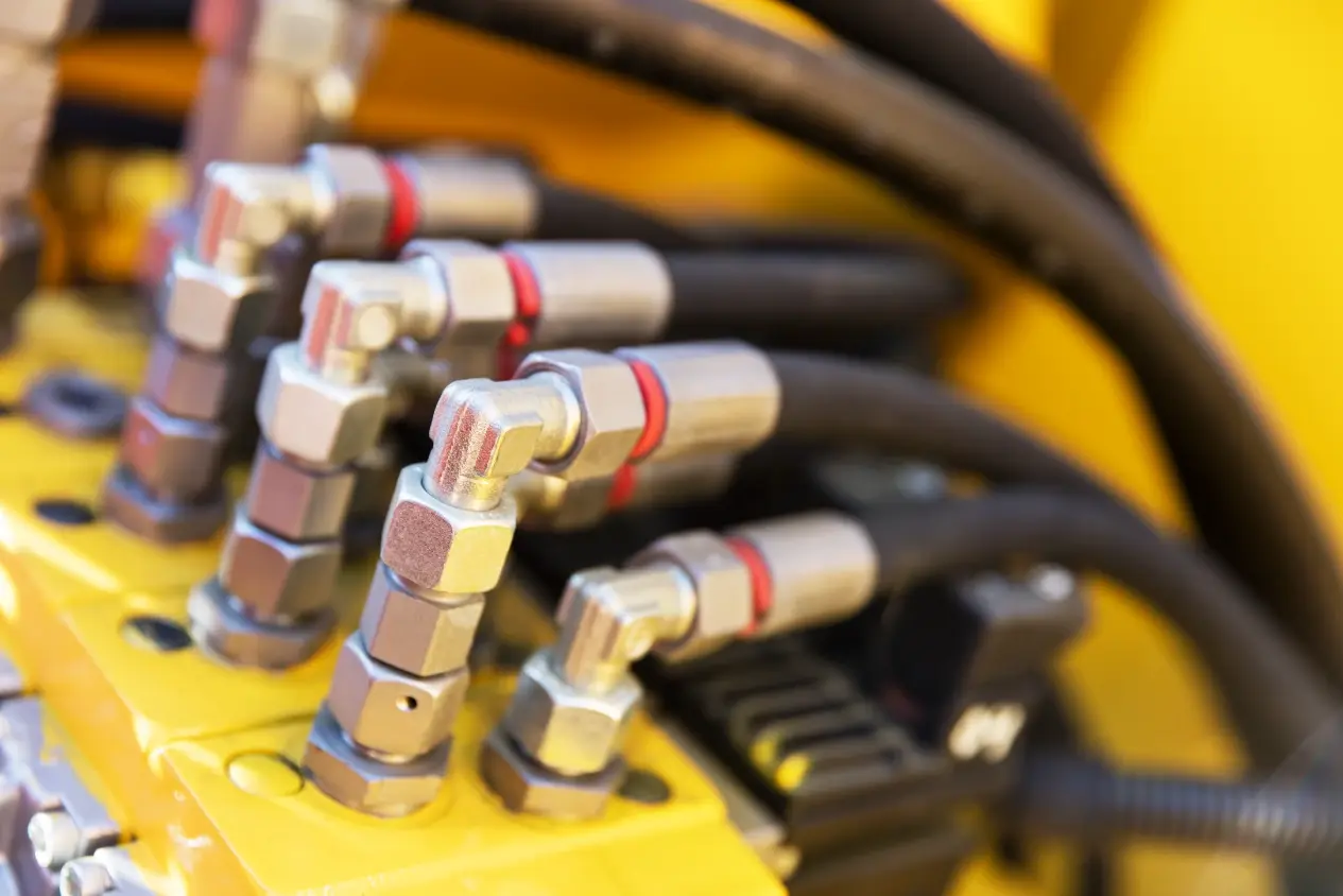 Hydraulic hose fittings on a heavy equipment manifold block serviced at Chris's Diesel Service in Midland TX